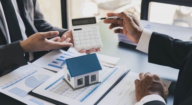 House model with agent and customer discussing calculate for price contract to buy, get insurance or loan real estate or property.
