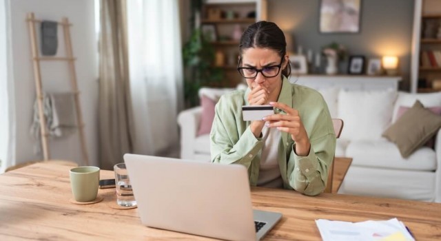 Worried woman looking at credit card