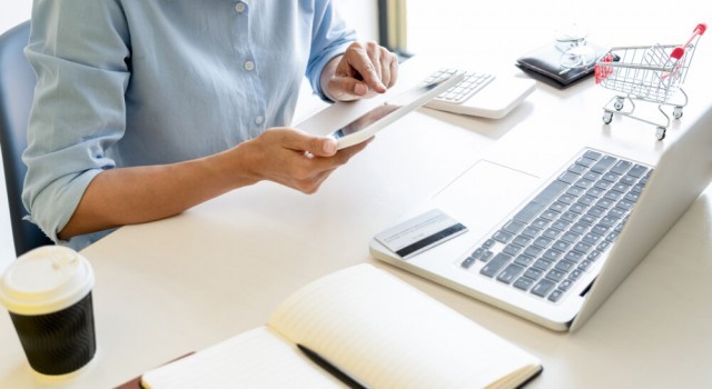 Man paying back his debts using laptop