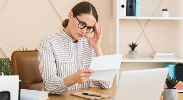 Stressed woman looking at debt bill