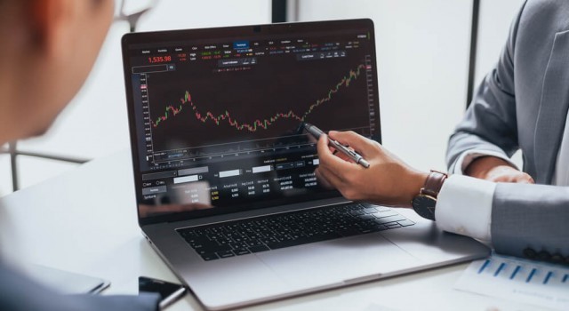 Two people analysing trading